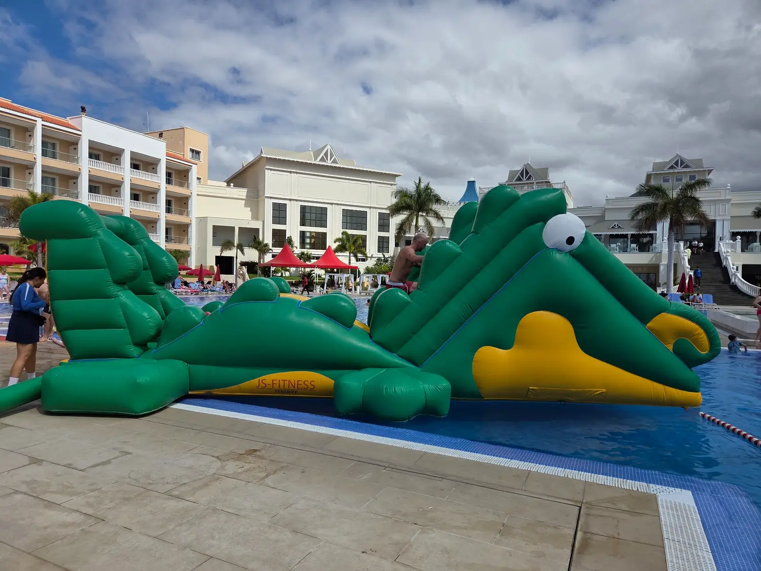 Castillo hinchable acuático Cocodrilo instalado junto a una piscina en Tenerife